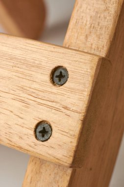 Yüzeyin altında ya da altında saklanmak için tahtaya saplanmış siyah Phillips baş metal vidalar yakın çekim makro görünümü, ahşap konsept