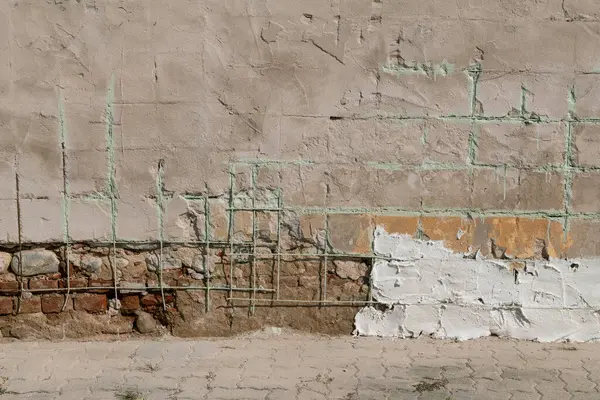 nfiltration damage and restoration of the plaster of the house. facade of a building, with restoration of a wall,