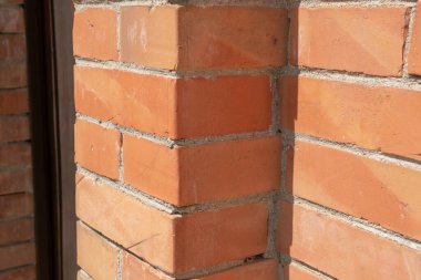 Tuğla duvar, dekoratif elementlerle donatılmış bir duvarın inşaatı bir binanın ön cephesinin inşaatı. yeşil bina