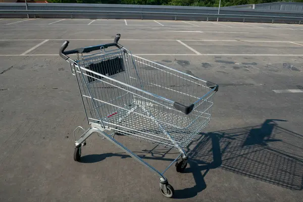 stock image The shopping cart in empty parking lot. shopping cart wanted, ready for shopping or synonymous with trade crisis, inflationary economy, news of the crisis of consumption. hypermarket closed for the holidays. shopping mall news