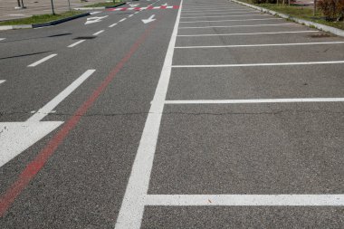 Zorunlu ok ve park çizgileri olan yol işaretleri. Asfalttaki semboller otoyol kurallarına göre dikte edilir. Yol ve park tasarımı, kentsel ve şehir dışı trafiği geliştirmek için hareket, frekans ve seyahat verilerinin incelenmesiyle başlar.