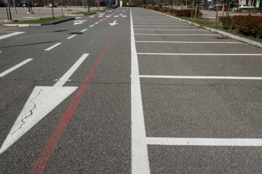 Zorunlu ok ve park çizgileri olan yol işaretleri. Asfalttaki semboller otoyol kurallarına göre dikte edilir. Yol ve park tasarımı, kentsel ve şehir dışı trafiği geliştirmek için hareket, frekans ve seyahat verilerinin incelenmesiyle başlar.