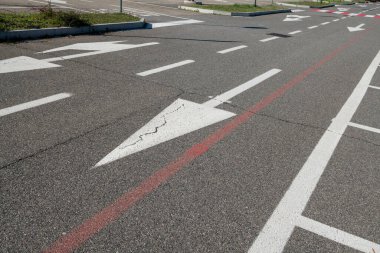 Zorunlu ok ve park çizgileri olan yol işaretleri. Asfalttaki semboller otoyol kurallarına göre dikte edilir. Yol ve park tasarımı, kentsel ve şehir dışı trafiği geliştirmek için hareket, frekans ve seyahat verilerinin incelenmesiyle başlar.