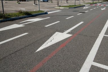 Zorunlu ok ve park çizgileri olan yol işaretleri. Asfalttaki semboller otoyol kurallarına göre dikte edilir. Yol ve park tasarımı, kentsel ve şehir dışı trafiği geliştirmek için hareket, frekans ve seyahat verilerinin incelenmesiyle başlar.