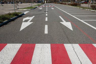 Zorunlu ok ve park çizgileri olan yol işaretleri. Asfalttaki semboller otoyol kurallarına göre dikte edilir. Yol ve park tasarımı, kentsel ve şehir dışı trafiği geliştirmek için hareket, frekans ve seyahat verilerinin incelenmesiyle başlar.