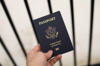 hand holding a passport with a flag of the united states of america