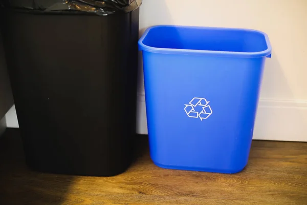 plastic trash can with recycle bin in the background