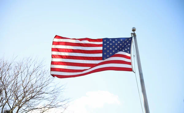 アメリカの国旗は青い空を背景に手を振る — ストック写真
