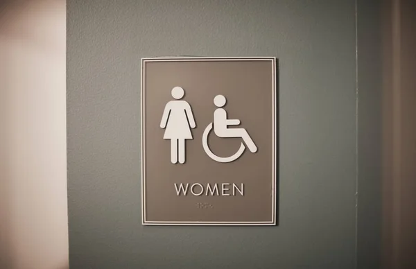 障害者のシンボルと玄関の出口があるトイレの看板 — ストック写真