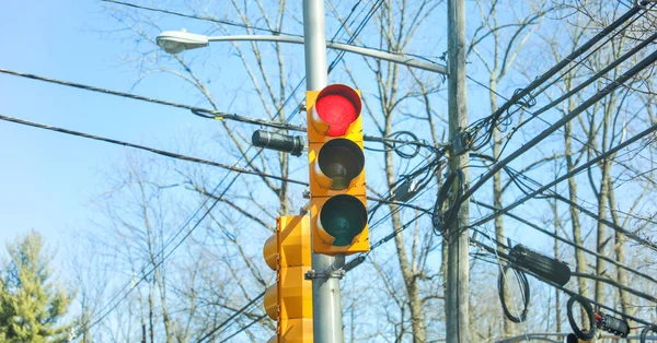 traffic lights with yellow light and blue sky, close up