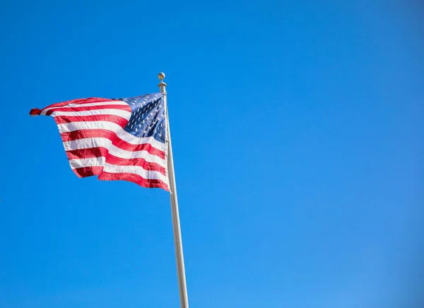 american flag waving on blue sky background