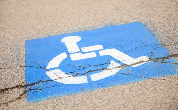 道路上の青いハンデ記号は 障害者のためのアクセシビリティとモビリティ支援のための普遍的なシンボルであり 平等な機会と包含を表します — ストック写真