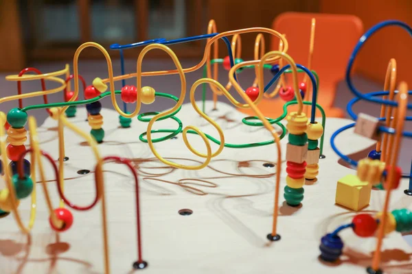classic beads maze toy featuring colorful beads on wires, which kids can move around. Symbolizes early childhood development of motor skills and hand-eye coordination, as well as the concept of cause and effect