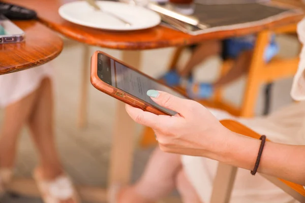people holding phones at a dining table symbolizes the prevalence of technology in our modern lives, but also the potential distraction and lack of presence in social situations