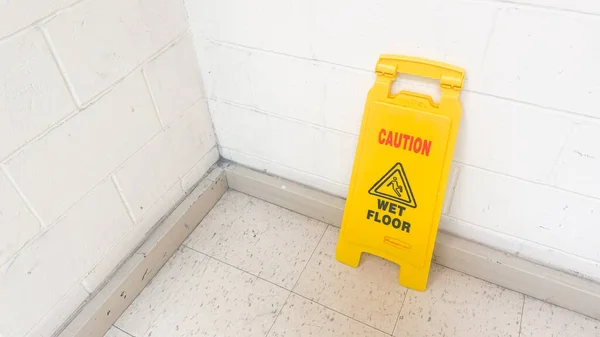 黄色的湿地板标志是警告和警告的标志 标志着一个滑和潜在的危险地区 它代表着安全 预防以及在公众中的关注和警觉的必要性 — 图库照片