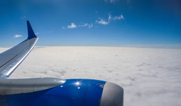Aerial View Window Seat Captures Majestic Airplane Wing Soaring Clouds Stock Photo