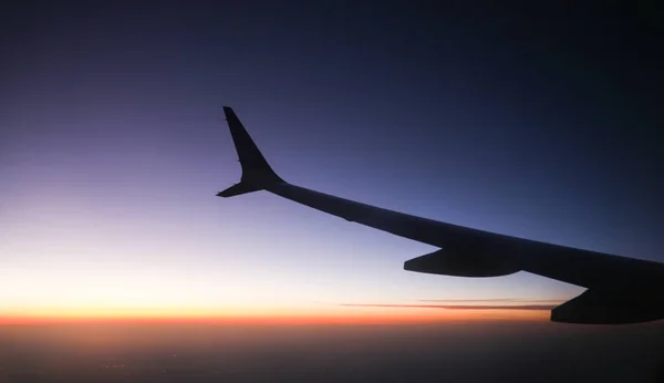 在日落的天空中俯瞰机翼的飞机景观象征着自由 冒险和透视 它代表了旅行的乐趣和世界的美丽 — 图库照片