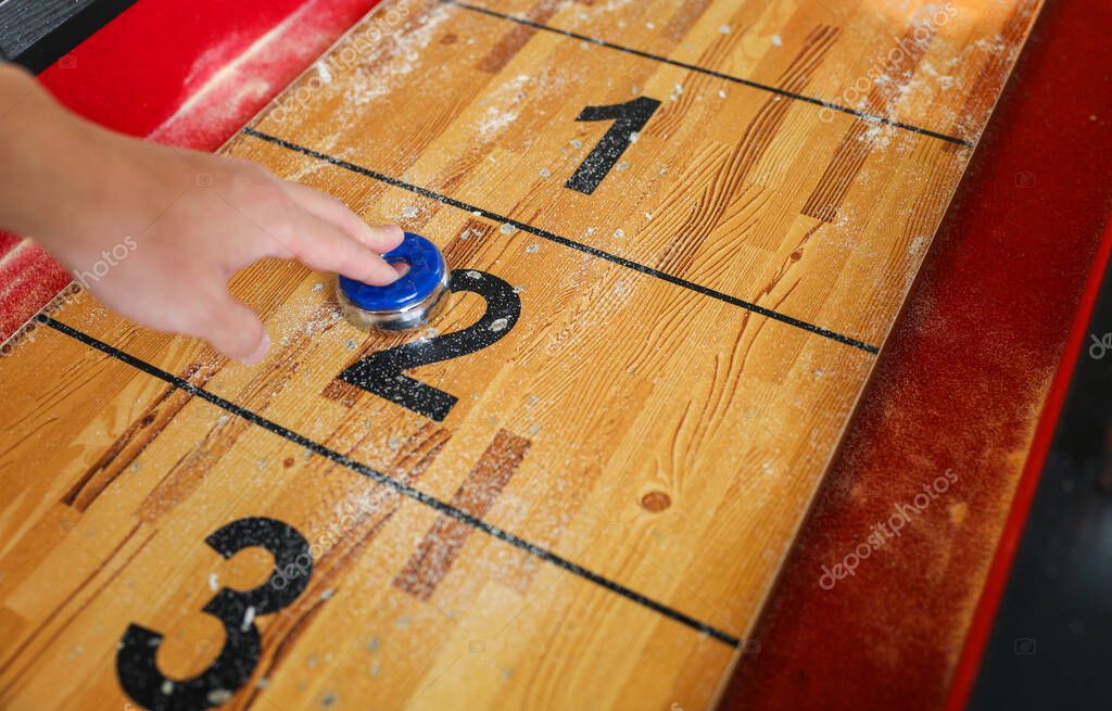 Shuffleboard es un juego de precisión y estrategia, donde los jugadores deslizan discos pesados