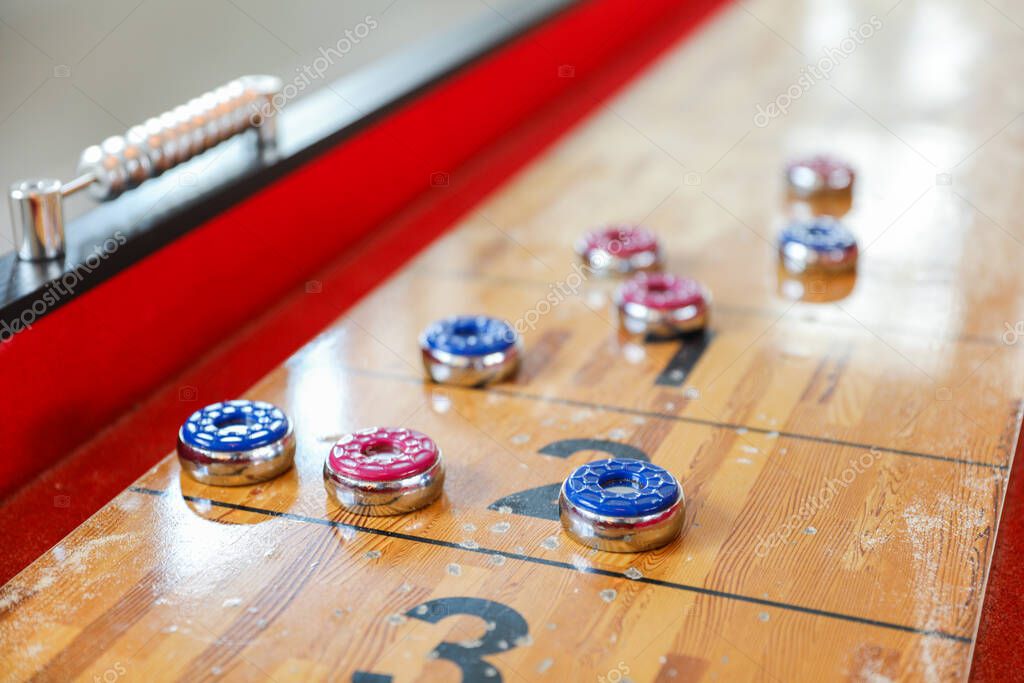 Shuffleboard es un juego de precisión y estrategia, donde los jugadores deslizan discos pesados