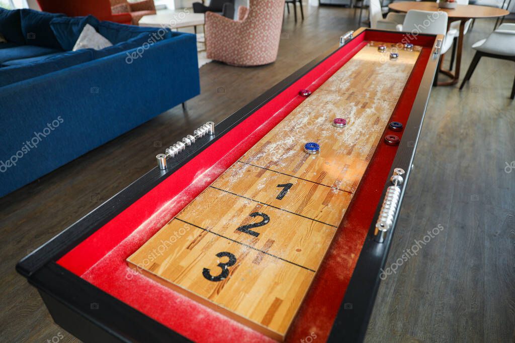 Shuffleboard es un juego de precisión y estrategia, donde los jugadores