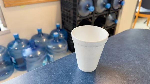 テーブルの上の発泡スチロールカップは 利便性と使い捨てを象徴するだけでなく 環境に対する使い捨てプラスチックの有害な影響を表します — ストック写真
