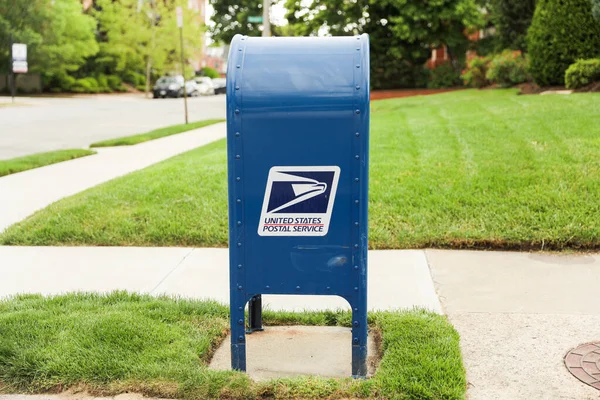 緑の背景に青いポストのあるメールボックスの投稿 — ストック写真