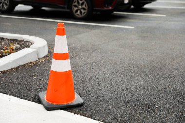 Turuncu inşaat konileri, yol çalışması ve dikkat sembolleri, parlak gün ışığında sokakta duruyor, gelişmeyi ve geçici bozulmaları temsil ediyor