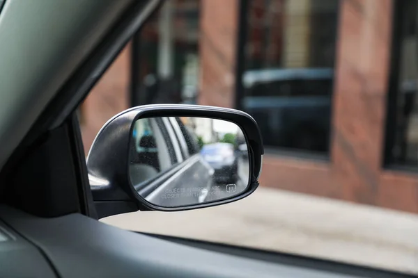 A car mirror reflects the journey ahead, symbolizing self-reflection, perspective, awareness, and the constant pursuit of progress