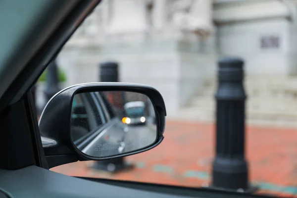A car mirror reflects the journey ahead, symbolizing self-reflection, perspective, awareness, and the constant pursuit of progress