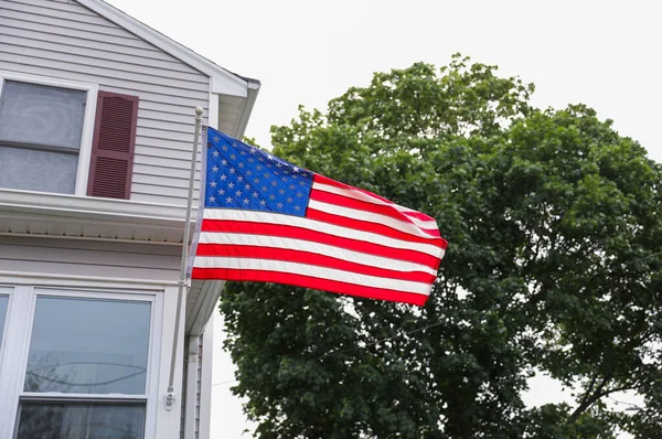 stock image The US flag, a symbol of patriotism and freedom, waves proudly against a blue sky, embodying the spirit of American holidays like July 4th and Memorial Day