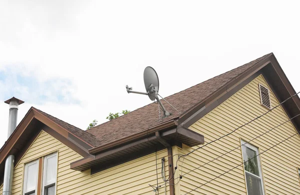 The satellite dish and radio antennas atop houses represent the transformative power of technology, connecting people globally and enabling access to information, communication, and entertainment