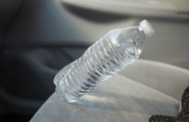 Plastik bir su şişesini sıkıca kavramak, çevresel etkiyi ve tek kullanımlık plastik atıkları azaltma aciliyetini sembolize ediyor.