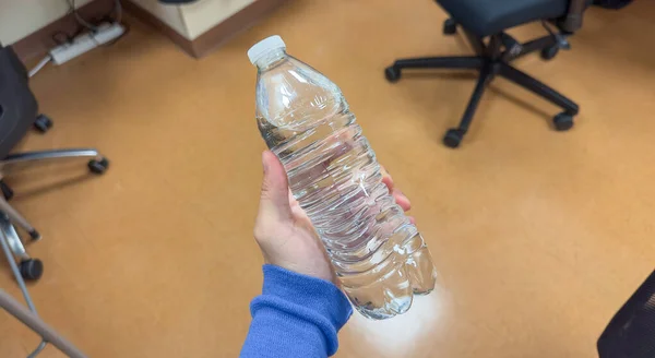 Hand Tightly Gripping Plastic Water Bottle Symbolizing Environmental Impact Urgency — Stock Photo, Image