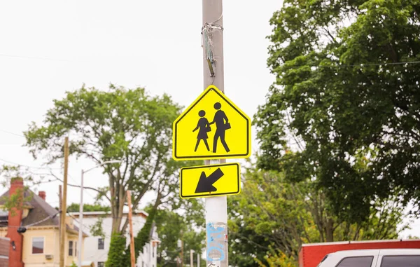 Żółty Znak Dla Pieszych Stoi Wysoki Ruchliwej Ulicy Symbolizujący Bezpieczeństwo — Zdjęcie stockowe