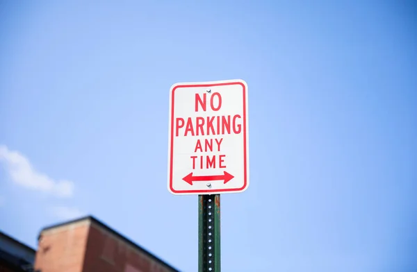 賑やかな街の通りには駐車場の看板はなく 混沌とした都会の風景の中で秩序と制限を思い出させる大胆な赤い文字があります — ストック写真
