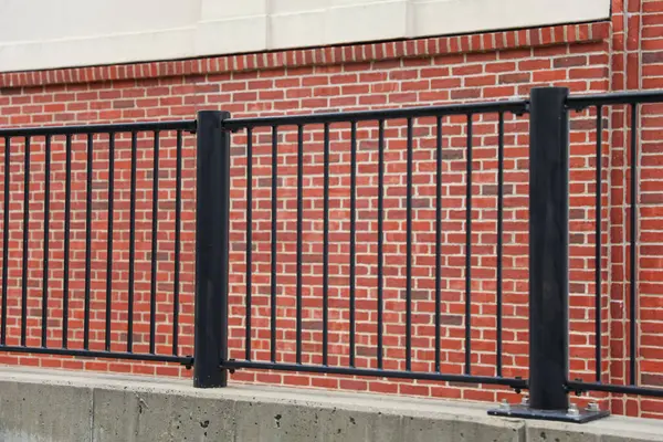 金属格子と白い柵のあるレンガの壁 — ストック写真