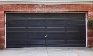 Garajı olan bir evin siyah metal kapısı.