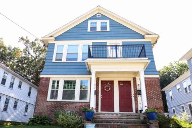 İki pencereli ve kırmızı verandalı mavi tuğla ev