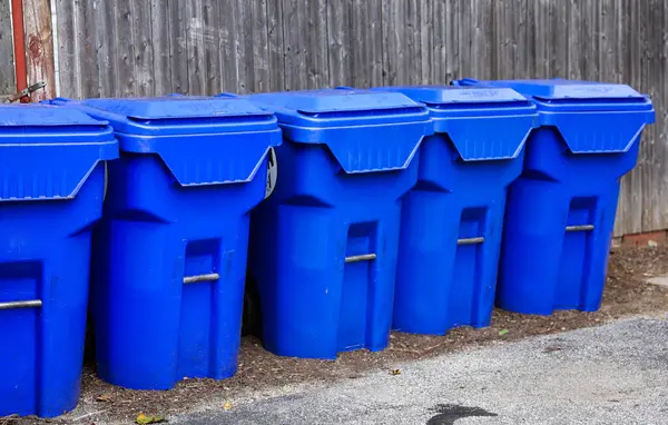 collection of blue plastic containers for the trash.