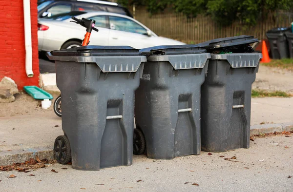 a row of black trash cans