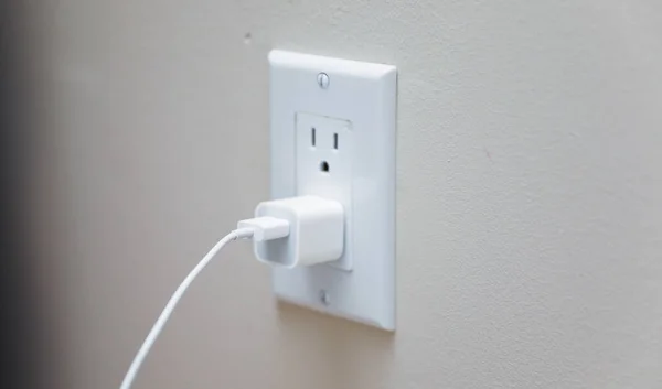 electric outlet plug on white wall background, close up