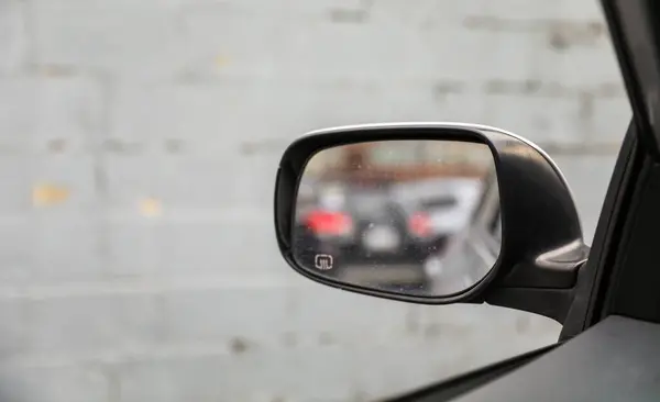 close up view of mirror with black car