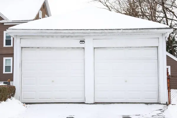 a garage with a snow covered roof and a fire hydrant