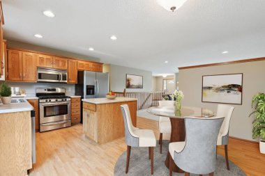 Mutfak içi masa ve ahşap dolaplarla dolu.