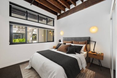 Geniş pencereli, modern bir yatak odası.