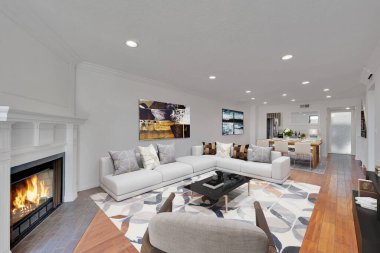 Modern oturma odasının içinde şömine ve kanepe var.