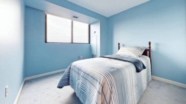 Modern bir yatak odasının içinde mavi duvarlar var.
