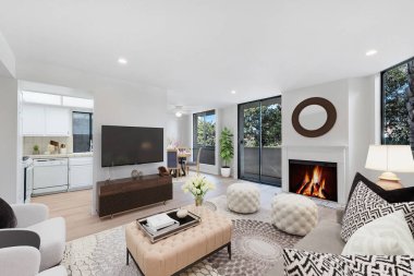 Modern oturma odasının içinde şömine ve kanepe var.