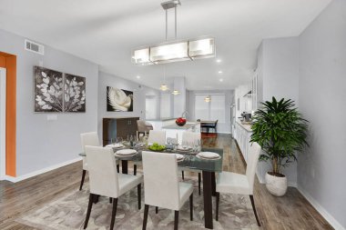 Ahşap zeminli, beyaz duvarlı ve sandalyeli bir masa. 3d oluşturma 