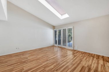 Beyaz duvarları ve tahta zemini olan boş bir oda.